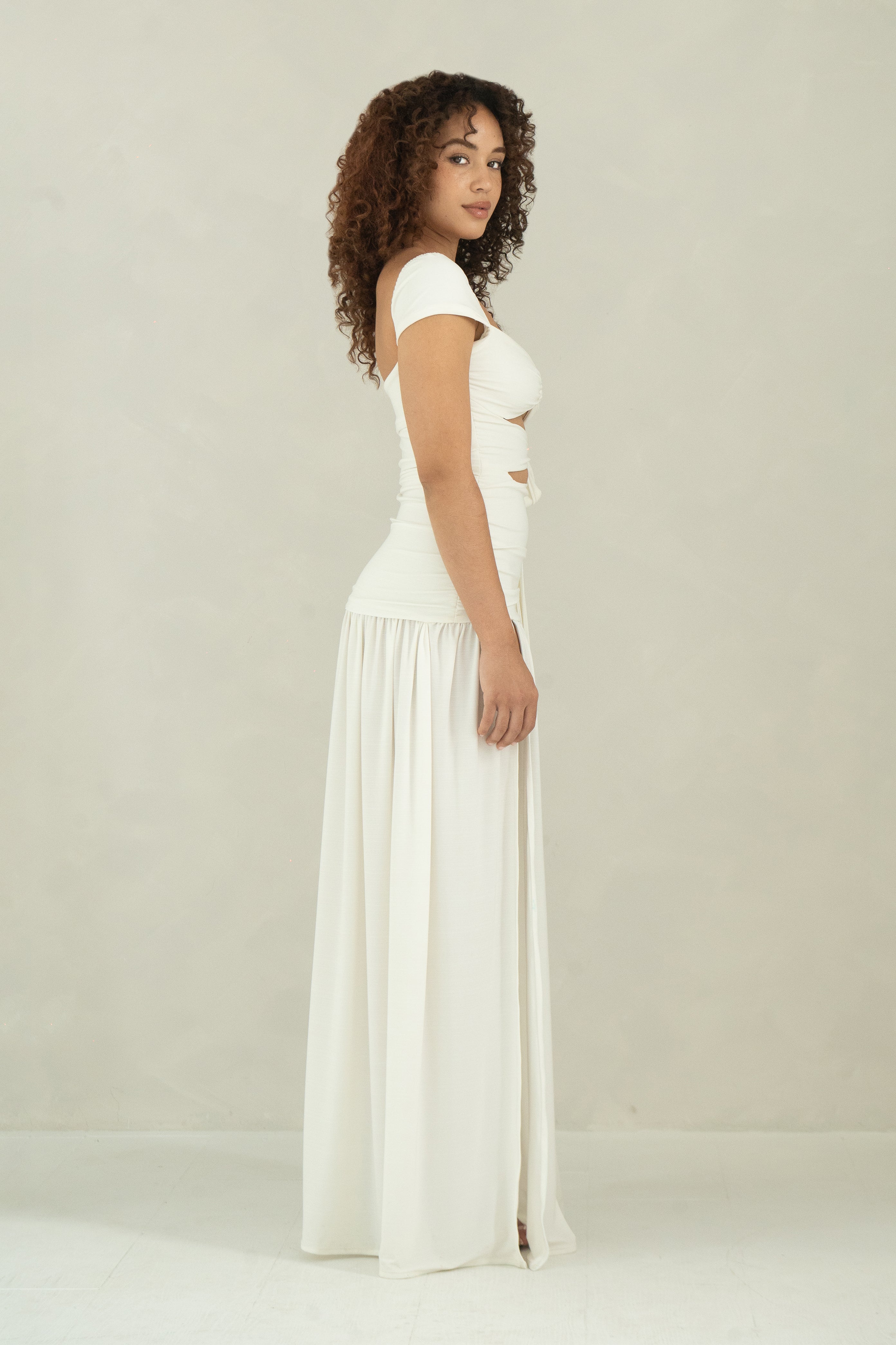 Side view of floor length white dress with cap sleeves