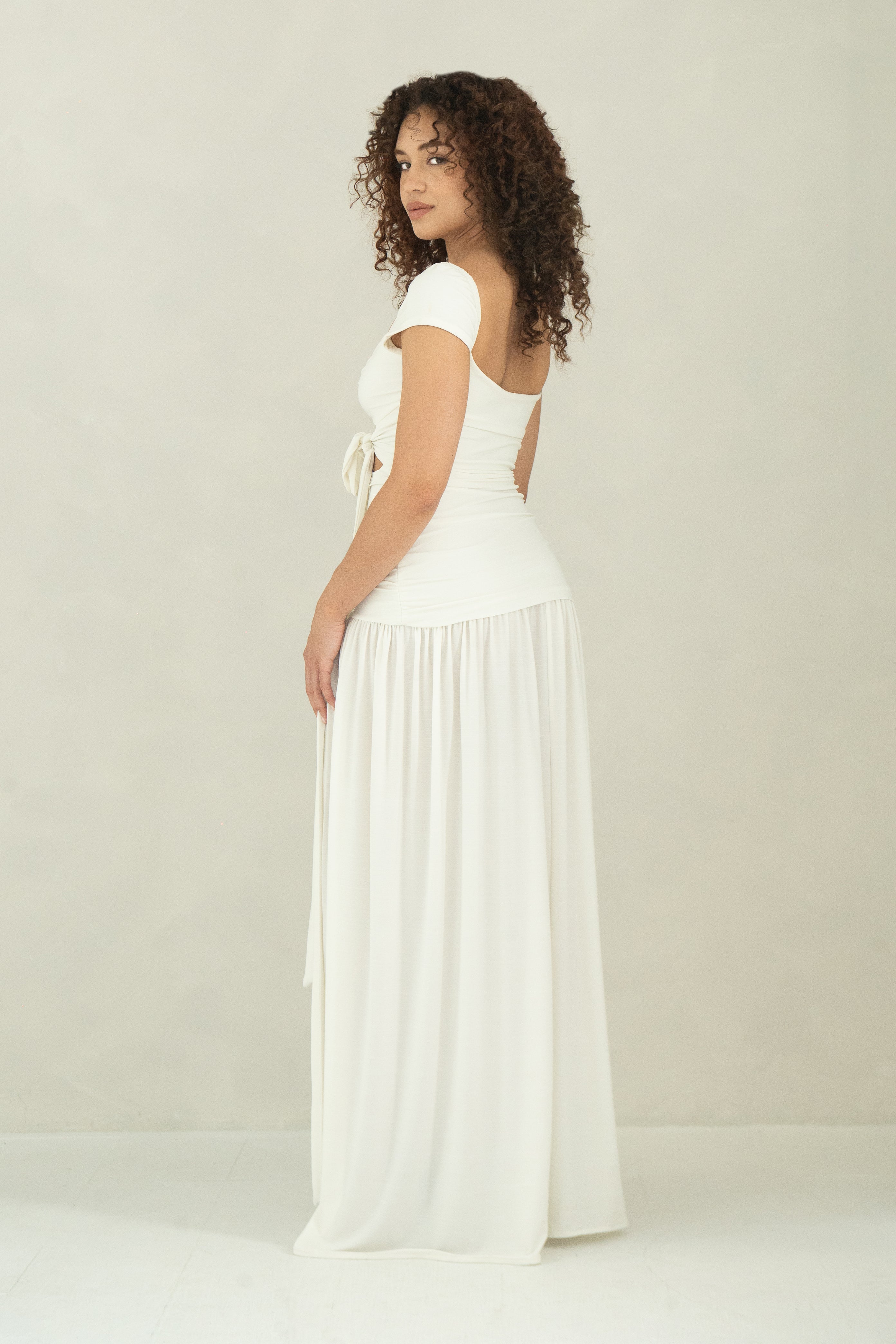 Floor length white dress with cap sleeves, ring detail and front slit