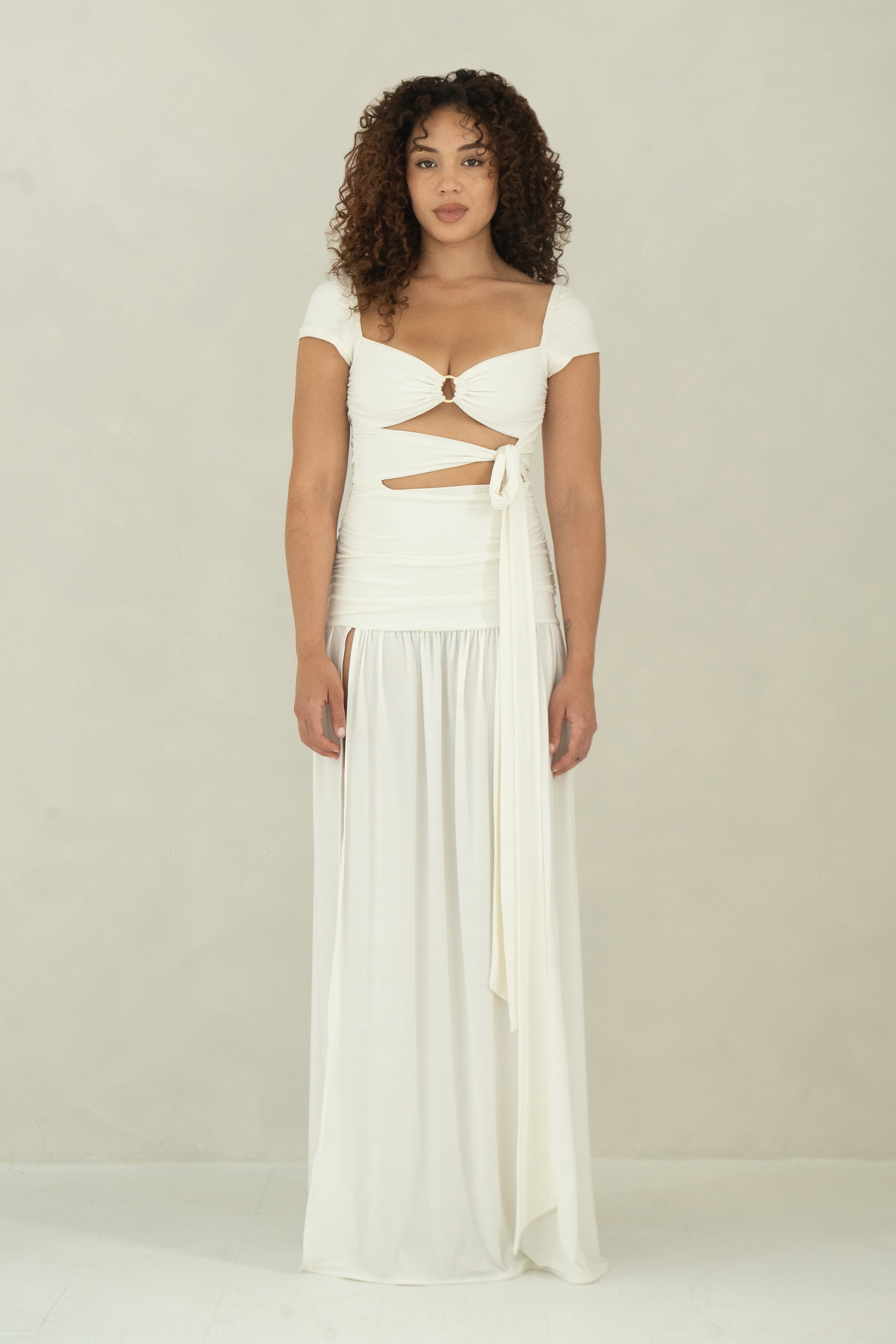 Floor length white dress with cap sleeves, ring detail and front slit