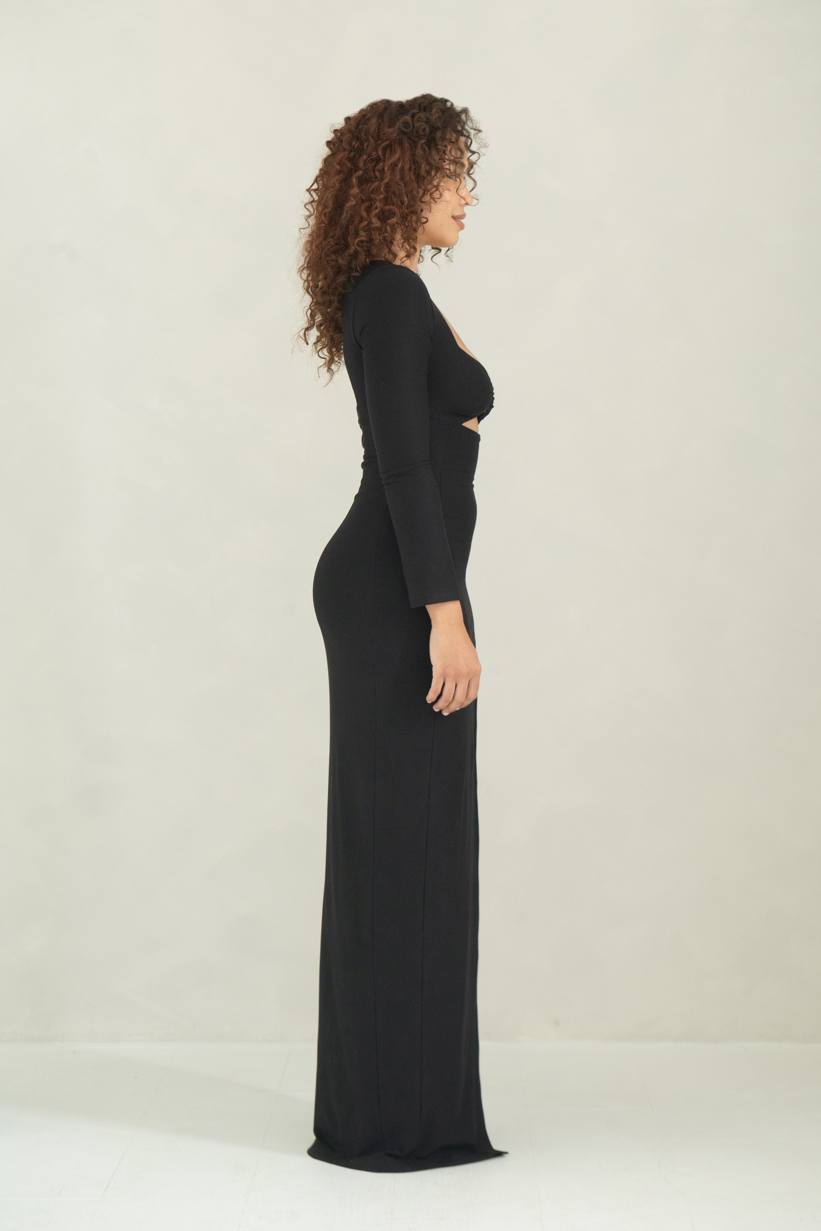 Long sleeve floor length black evening dress with a ring detail, bust cutout and front slit