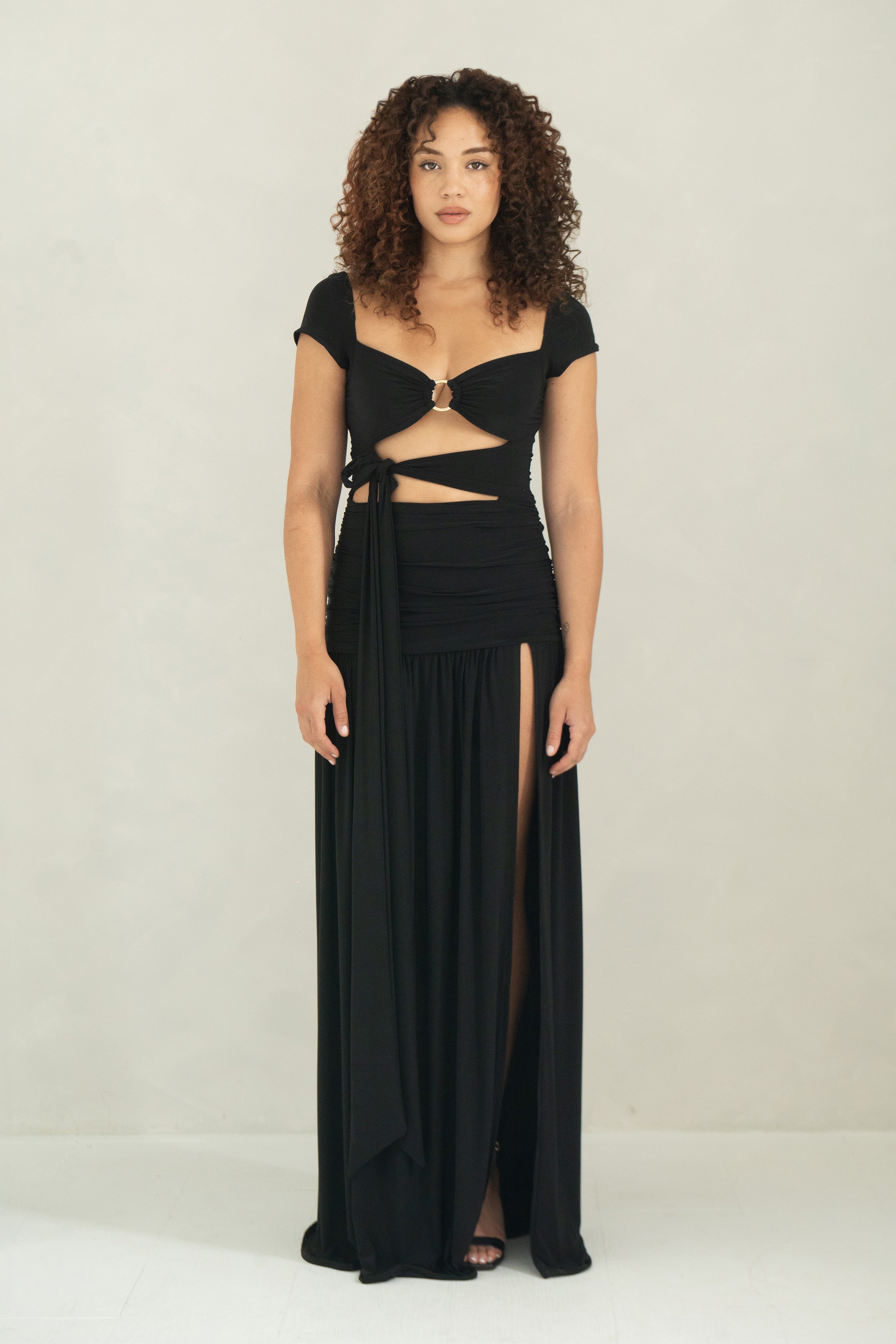 Floor length black dress with cap sleeves, ring detail and front slit